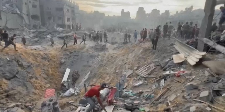 Palestinos procurando sobreviventes em uma cratera após um ataque a um campo de refugiados em Jabali Palestinos procurando sobreviventes em uma cratera após um ataque a um campo de refugiados em Jabali