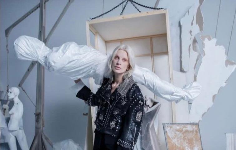 A campanha publicit&aacute;ria mostra uma modelo de p&eacute;, carregando uma est&aacute;tua de tamanho adulto enrolada em um len&ccedil;ol branco sobre o ombro