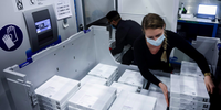 Funcionários colocam vacinas Pfizer-BioNtech COVID-19 em um freezer na fábrica da Pfizer em Puurs, Bélgica, em 22 de fevereiro