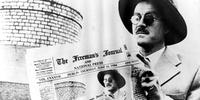 James Joyce com um jornal irlandês em alusão ao 16 de junho de 1904