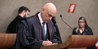 O ministro Alexandre de Moraes assinando o termo de posse como presidente do TSE